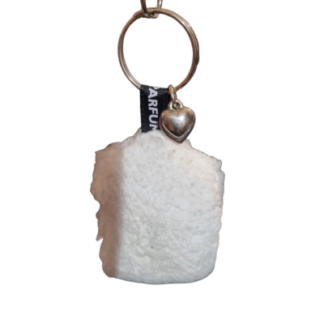 Un coussin de clé parfumé au toucher doux comprenant une breloque rectangulaire blanche duveteuse et un petit pendentif métallique en forme de cœur, le tout attaché à un porte-clés en métal.