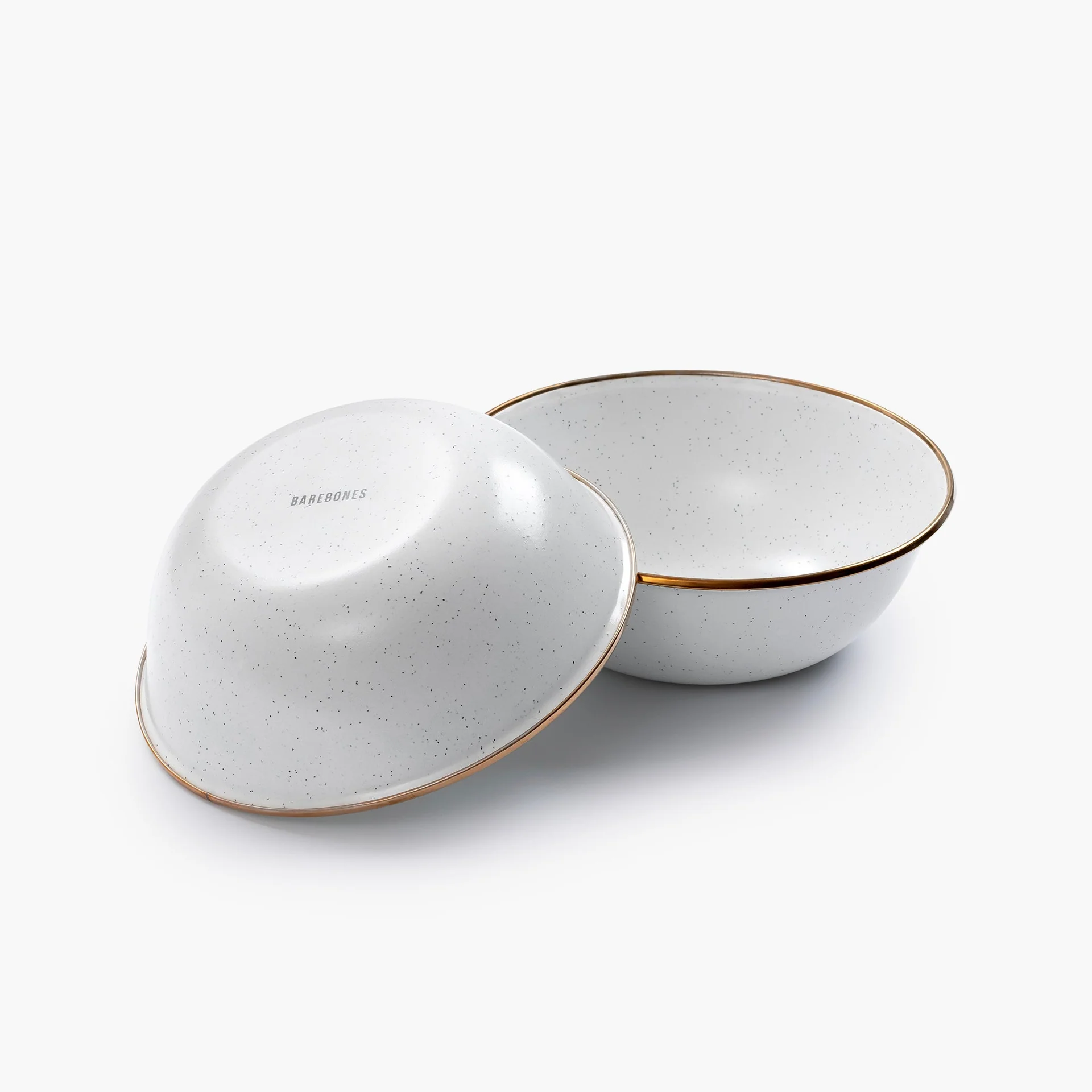Set de 2 bols email blancs avec motif moucheté et bord doré : un bol est droit, montrant l'intérieur, l'autre à l'envers affichant la marque "BAREBONES".