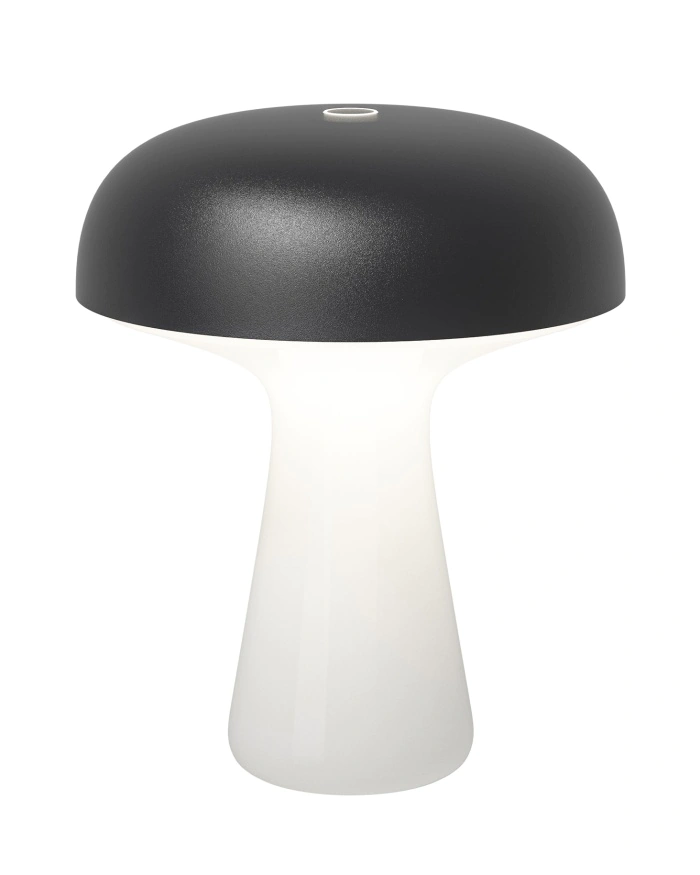 Lampe de table moderne avec un plateau noir mat en forme de champignon et une base blanche incurvée, qui s'illumine doucement.