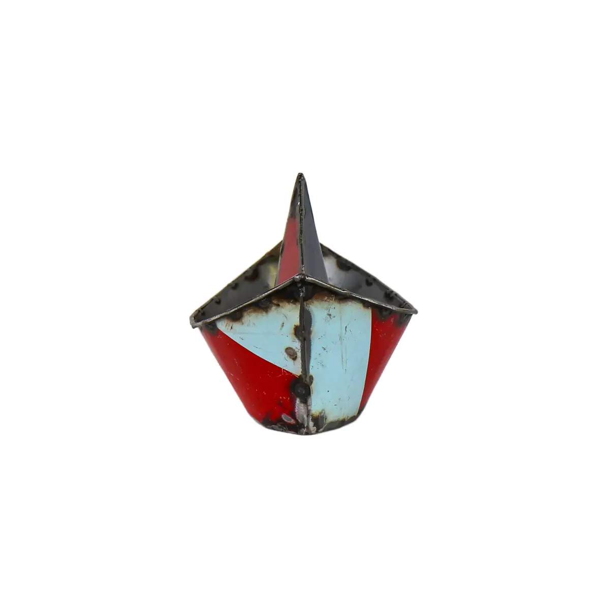 Le "Bateau origami upcycling en métal" est un petit bateau-jouet en métal de style ancien avec un sommet pointu, peint dans des couleurs aléatoires et présentant des signes de rouille et d'usure. Le bateau est photographié sur un fond blanc uni.