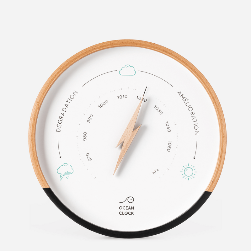Le Baromètre mural est un baromètre mural rond avec un cadre en bois, mesurant la pression de 970 à 1050 hPa. Il comporte des icônes d'orage, de nuage et de soleil pour les changements de temps, ainsi qu'une aiguille en forme d'éclair.