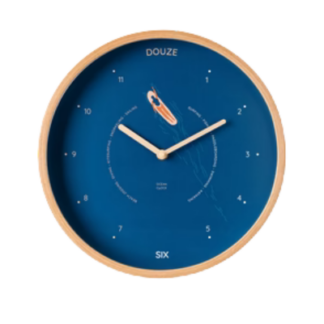 L'Horloge Marine Océan est une horloge murale ronde avec un cadre en bois, un cadran bleu, des index minimalistes, "DOUZE" à 12 heures, "SIX" à 6 heures, des aiguilles blanches et une illustration de comète près du centre.