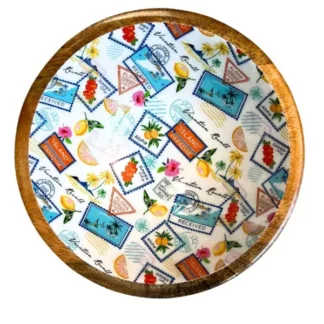 Le Bol manguier 25 cm tropical est un bol rond en bois dont l'intérieur est orné d'un thème tropical vibrant, avec des timbres de cartes postales, des fruits, des fleurs, des palmiers et des motifs de voyage sur un fond blanc.