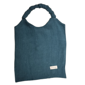 Un "Bavoir en lin adulte" en tissu bleu présente une poignée froissée et une petite étiquette blanche cousue dans le coin inférieur droit, sur fond blanc.