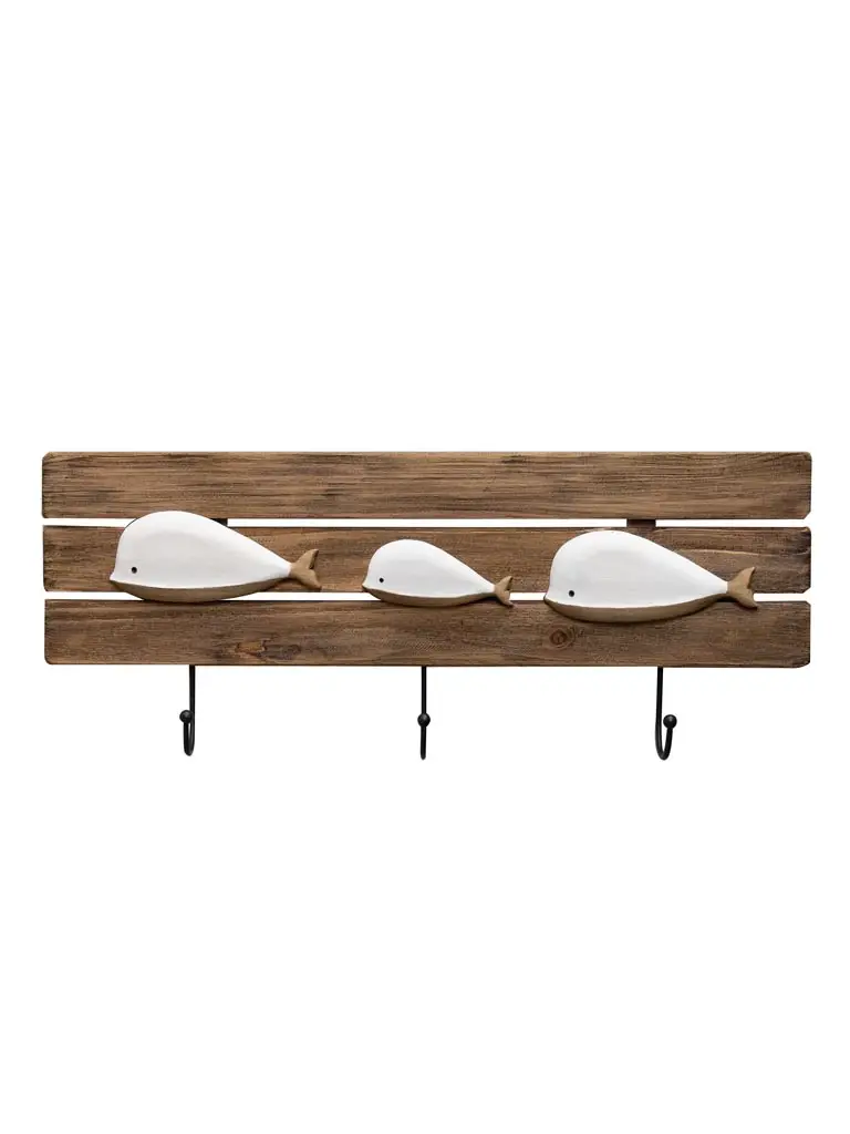 Le Porte-manteau baleines est une étagère murale en bois dotée de trois crochets métalliques et décorée de trois figures de baleines blanches de tailles différentes sur les lattes de bois.