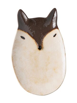 Assiette en céramique en forme de visage de renard, avec une glaçure brune sur les oreilles et le haut de la tête, des yeux et un nez noirs, et une partie inférieure de couleur crème. Le design est minimaliste et stylisé.