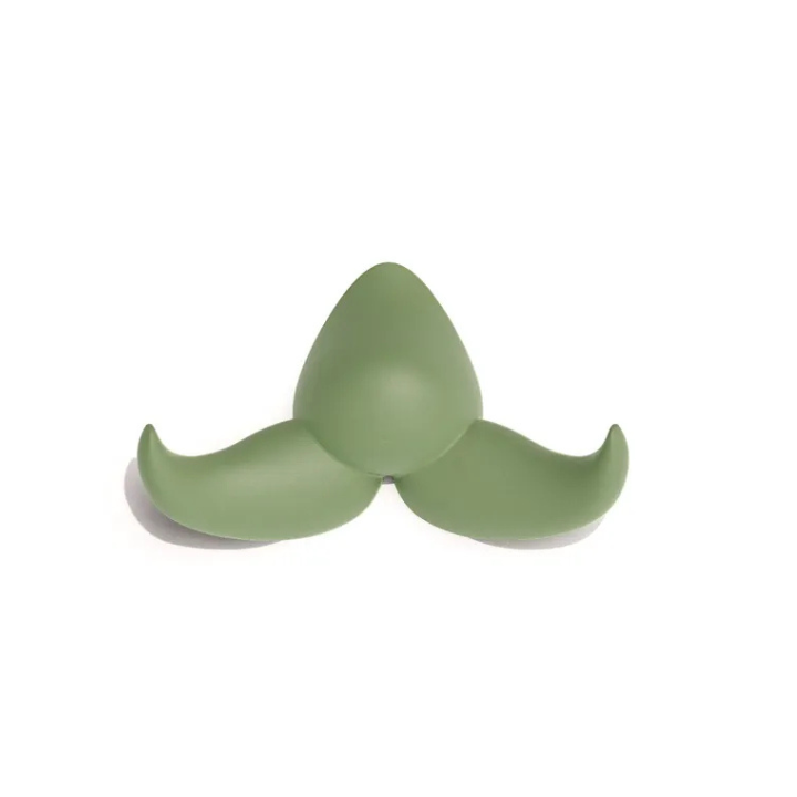 Une moustache Patère Baffo vert clair, un crochet en silicone à trois branches avec un centre arrondi et des bords courbés, isolée sur un fond blanc.