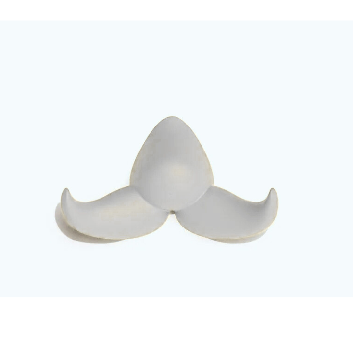 La moustache Patère Baffo est un crochet en céramique minimaliste, blanc, en trois parties, aux bords incurvés, disposés en trèfle ou en triangle, sur un fond clair uni.