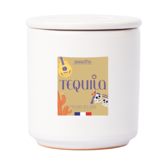 La Tequila Bougie Cocktail est un récipient en céramique blanche avec un couvercle et une étiquette "Tequila", décorée d'une guitare, d'un cactus, d'illustrations de crânes, et des drapeaux français et mexicain dans le fond.