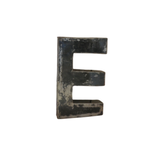 Une grande lettre "E" métallique tridimensionnelle avec une surface noire usée, similaire à la Lettre E déco métal recyclé 22cm, est isolée sur un fond blanc.