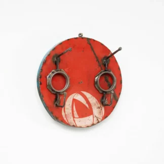 Une Patère double métal recyclé, présentant un motif rond en métal rouge altéré avec deux crochets en métal côte à côte et un logo blanc délavé sur la moitié inférieure, est accrochée à un mur blanc.