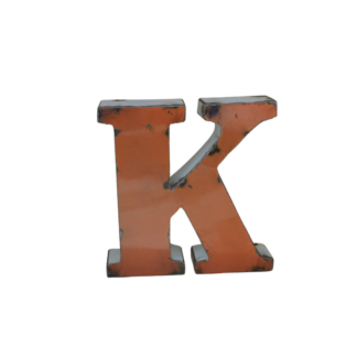 Une lettre "K" tridimensionnelle en métal orange avec des bords usés et des éraflures se tient debout sur un fond blanc - une pièce d'accentuation audacieuse, similaire à la Lettre J déco métal recyclé 15cm (Copie).