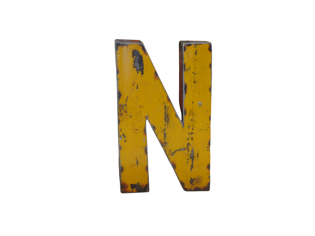 La Lettre N déco métal recyclé 22cm est une grande lettre jaune majuscule "N" avec un aspect vieilli et des éraflures noires visibles dans le style de la lettre m déco métal, présentée sur un fond blanc.