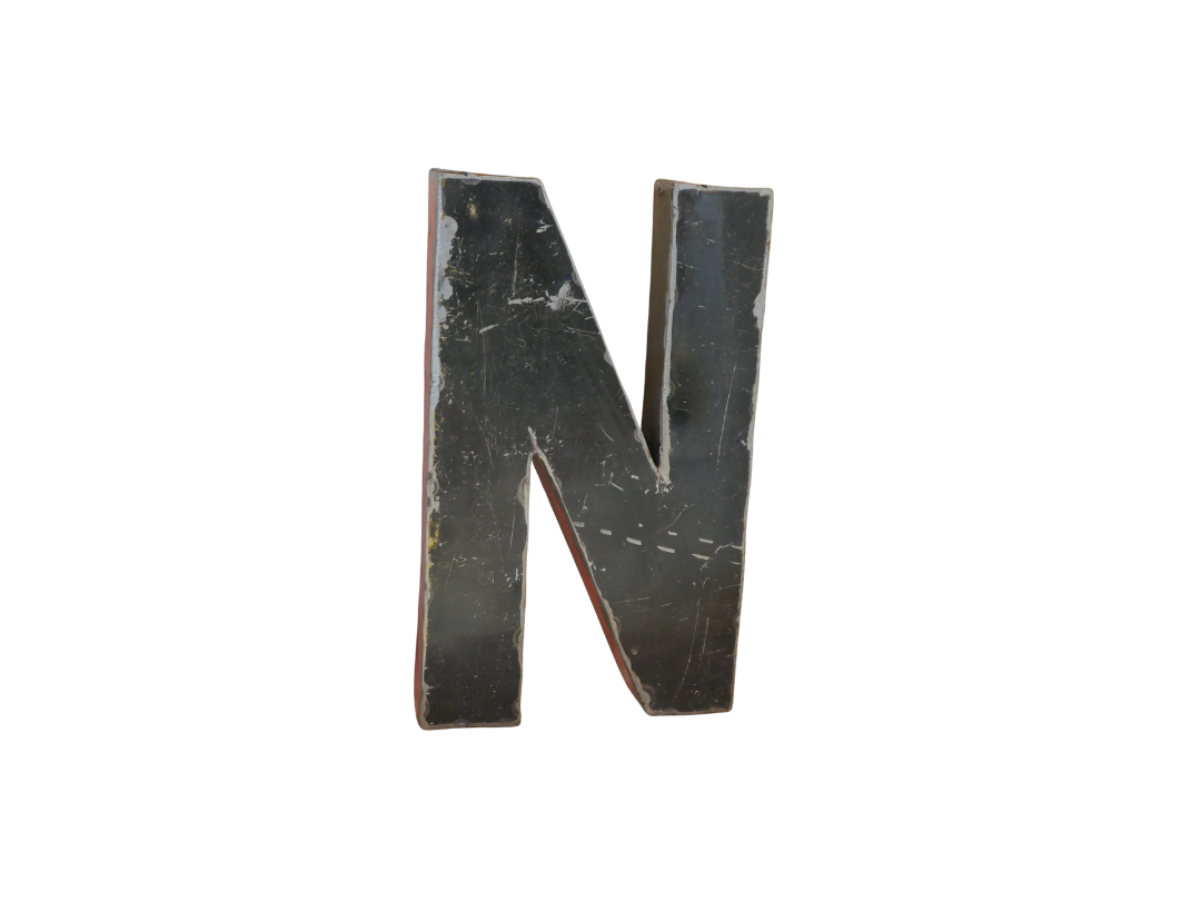 Un "N" noir en style déco métal, fabriqué à partir de métal recyclé, mesurant 22cm, avec des rayures et des bords usés, isolé sur un fond blanc. Produit : Lettre N déco métal recyclé 22cm.