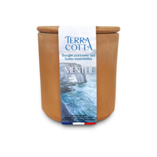 Un photophore en terre cuite avec un couvercle en bois, étiqueté "Terra Cotta Bougie parfumée aux huiles essentielles MENTHE", avec une image de falaises rocheuses et de vagues sur l'emballage.