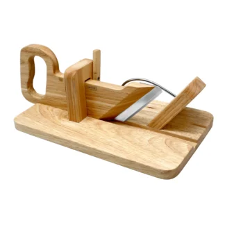 La Guillotine Bois Cuisine est une trancheuse en bois avec une poignée intégrée et une lame métallique tranchante inclinée sur une base plate, parfaite pour couper le pain, le fromage ou les saucisses.