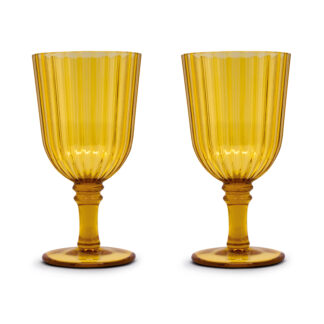 Deux gobelets en verre jaune strié avec des coupes évasées et des tiges courtes sont placés côte à côte sur un fond blanc.