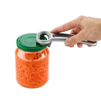 Une main utilise l'Ouvre Bocal VACIO pour ouvrir un bocal à couvercle vert contenant des légumes orange râpés, probablement des carottes.