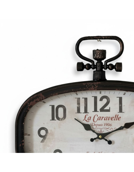 Gros plan sur l'Horloge Caravelle Murale, une horloge murale de style ancien avec une clé de remontage décorative sur le dessus, affichant environ 4:40 et portant la mention "La Caravelle Depuis 1906" en écriture rouge sur son cadran.