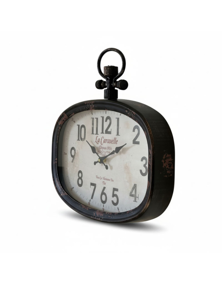 L'Horloge Caravelle Murale est une horloge de table noire ovale de style ancien, avec de grands chiffres noirs, des aiguilles ornées, "La Caravelle" sur son cadran blanc et un anneau décoratif sur le dessus.