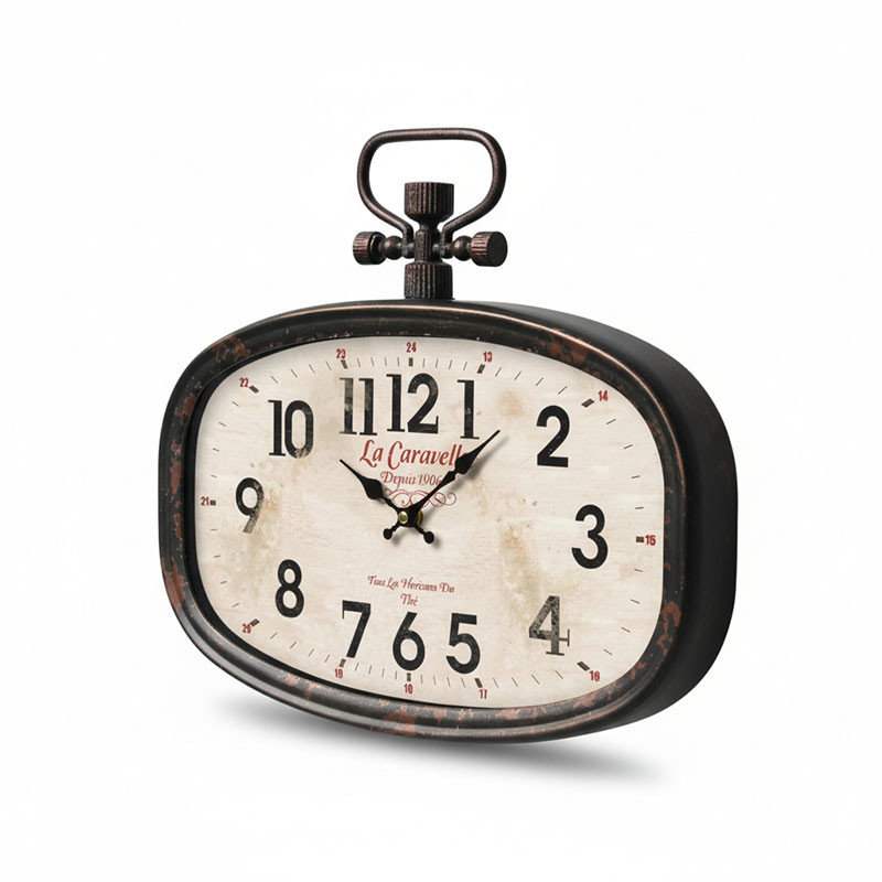 L'Horloge Caravelle Murale est une horloge de table ovale de style vintage avec un cadre noir, un cadran blanc, des chiffres noirs, une clé de remontage décorative sur le dessus, un cadran légèrement vieilli indiquant 10:10, et "La Caravelle" écrit en rouge.