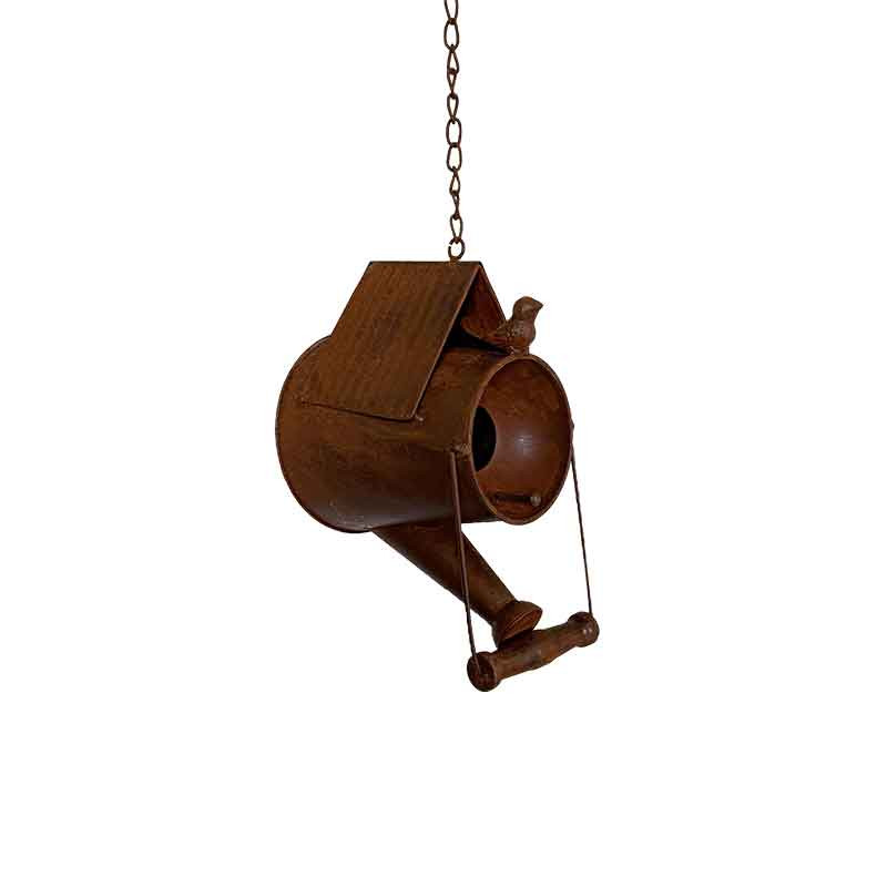 La suspension Oiseaux Fer est un nichoir suspendu fabriqué à partir d'un arrosoir en métal rouillé, doté d'un toit incliné, d'un trou d'entrée rond et surmonté d'un oiseau décoratif.