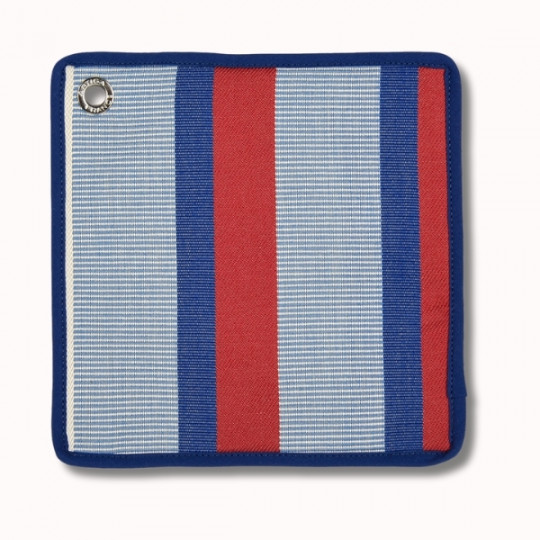 Une manique carrée en tissu avec des rayures verticales bleues, rouges et bleu clair, bordées de bleu, et un œillet métallique dans un coin pour la suspendre.