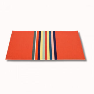 Le set de table Enduit (6 coloris) est un set de table rectangulaire rouge avec des rayures verticales vertes, orange, blanches, jaunes, bleues, marines et noires le long d'un bord, sur un fond blanc uni.