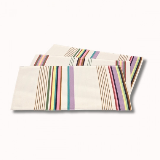 Le Set Table Enduit (6 coloris) présente trois serviettes rectangulaires blanches avec des rayures verticales violettes, vertes, jaunes, roses et bleues, empilées et se chevauchant légèrement sur un fond clair.