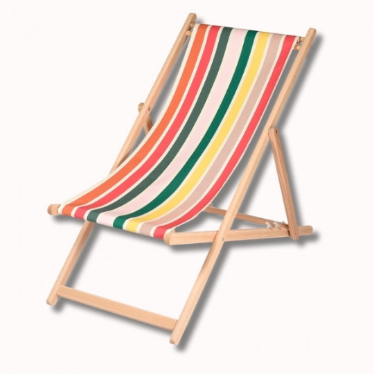 La Chaise Longue Hêtre est une chaise longue en bois dont l'assise est en tissu à rayures verticales rouges, vertes, jaunes et blanches sur fond uni.