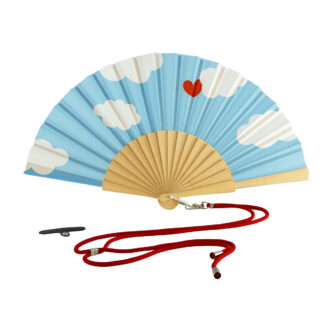 L'Éventail Bois Tissu (divers motifs) est un éventail pliant bleu avec des nuages blancs, un cœur rouge et une base marron clair. Il est précédé d'un cordon rouge muni d'un clip métallique et d'une petite attache noire.