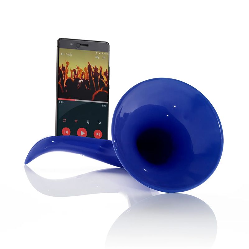 Un smartphone est placé dans l'« Amplificateur acoustique en céramique Scaramaz Basic pour smartphone » (version bleue), avec une application de lecture de musique affichant une scène de concert sur l'écran du téléphone.