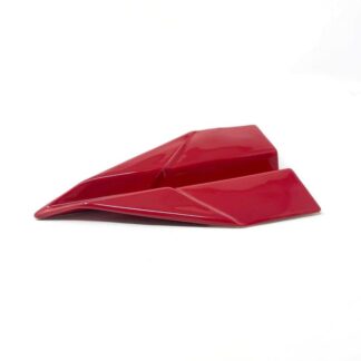 Un origami décoratif Avion, rouge et brillant, repose sur une surface blanche ; ses plis épurés et anguleux laissent deviner une structure solide plutôt que du papier.