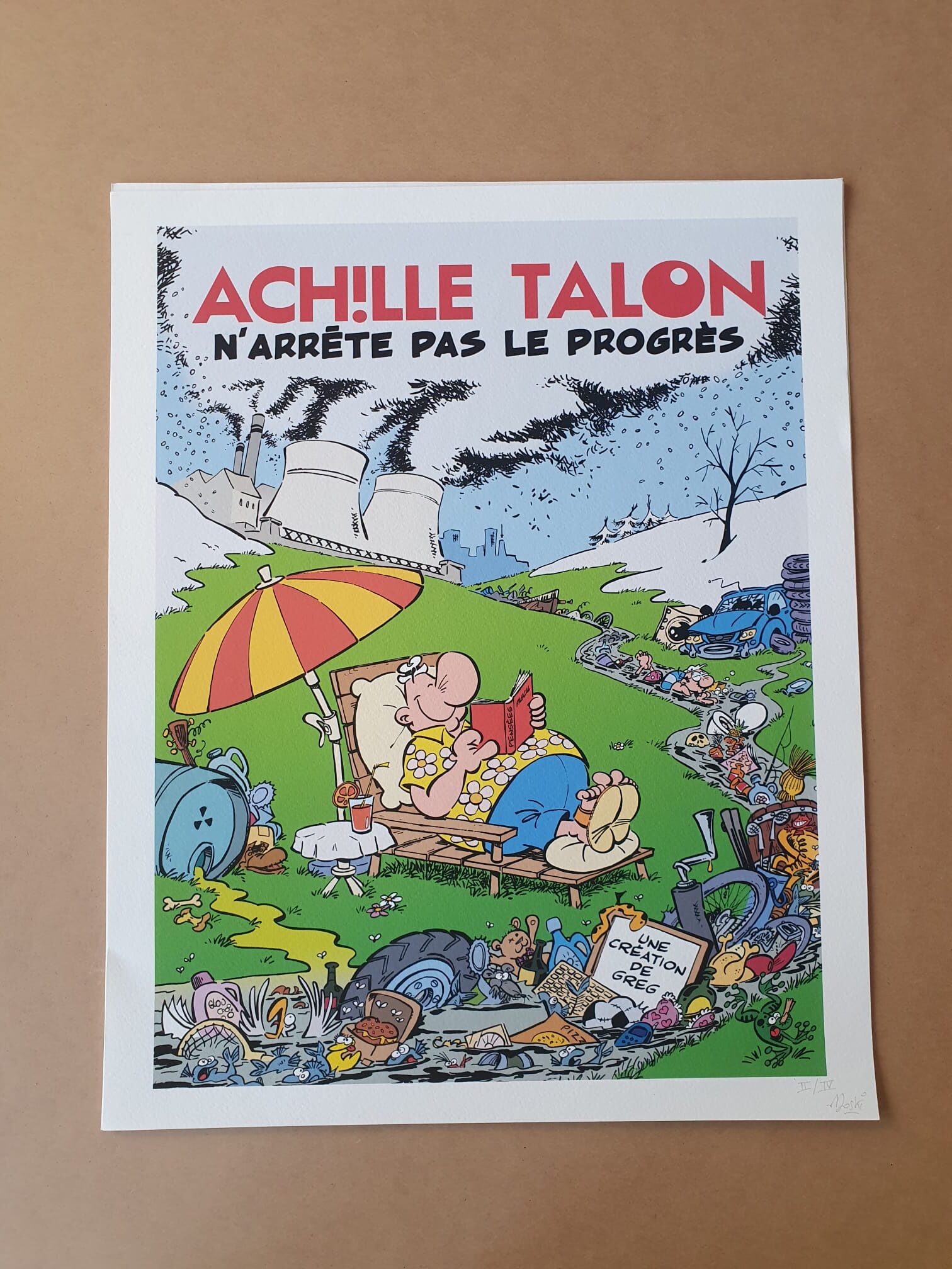 Il s’agit d’une lithographie de 40 × 50 cm intitulée « Lithographie Moski – Achille Talon n’arrête pas le progrès », représentant une affiche caricaturale d’Achille Talon se détendant dans un champ pollué et jonché de déchets, avec des usines et de la fumée en arrière-plan. En haut de l’œuvre figure le texte suivant : « Achille Talon n’arrête pas le progrès. ».