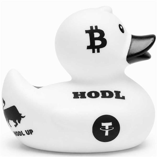 Canard de bain « Baby Garçon » en caoutchouc blanc, orné de symboles et de textes liés aux cryptomonnaies en noir, dont un logo Bitcoin sur la tête, l'inscription « HODL » sur le côté, une icône représentant un taureau et un logo Tether (USDT), le tout sur fond blanc.