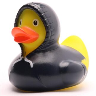 Un « Canard de bain Baby Garçon » : un canard en caoutchouc jaune vêtu d'une veste noire à capuche, dont la capuche est rabattue sur sa tête.