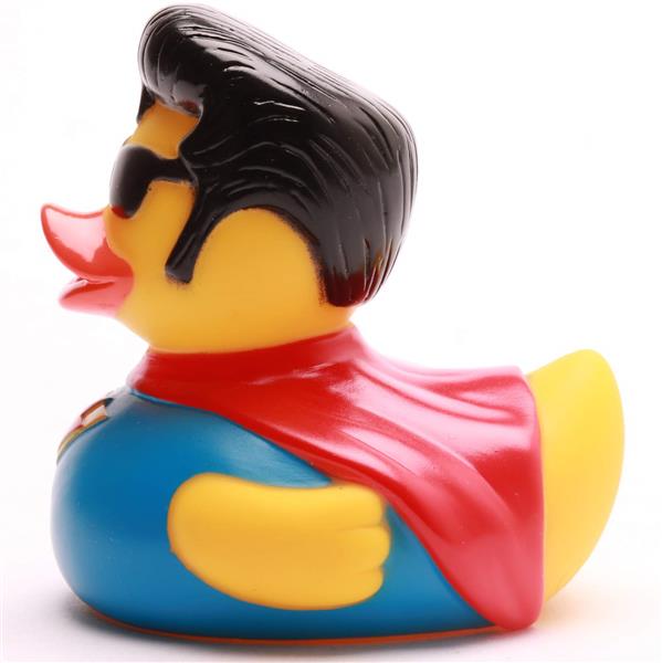 Canard en caoutchouc déguisé en super-héros, vêtu d'un costume bleu, d'une cape rouge, de lunettes de soleil noires et coiffé d'une coiffure noire, vu de profil sur un fond blanc.