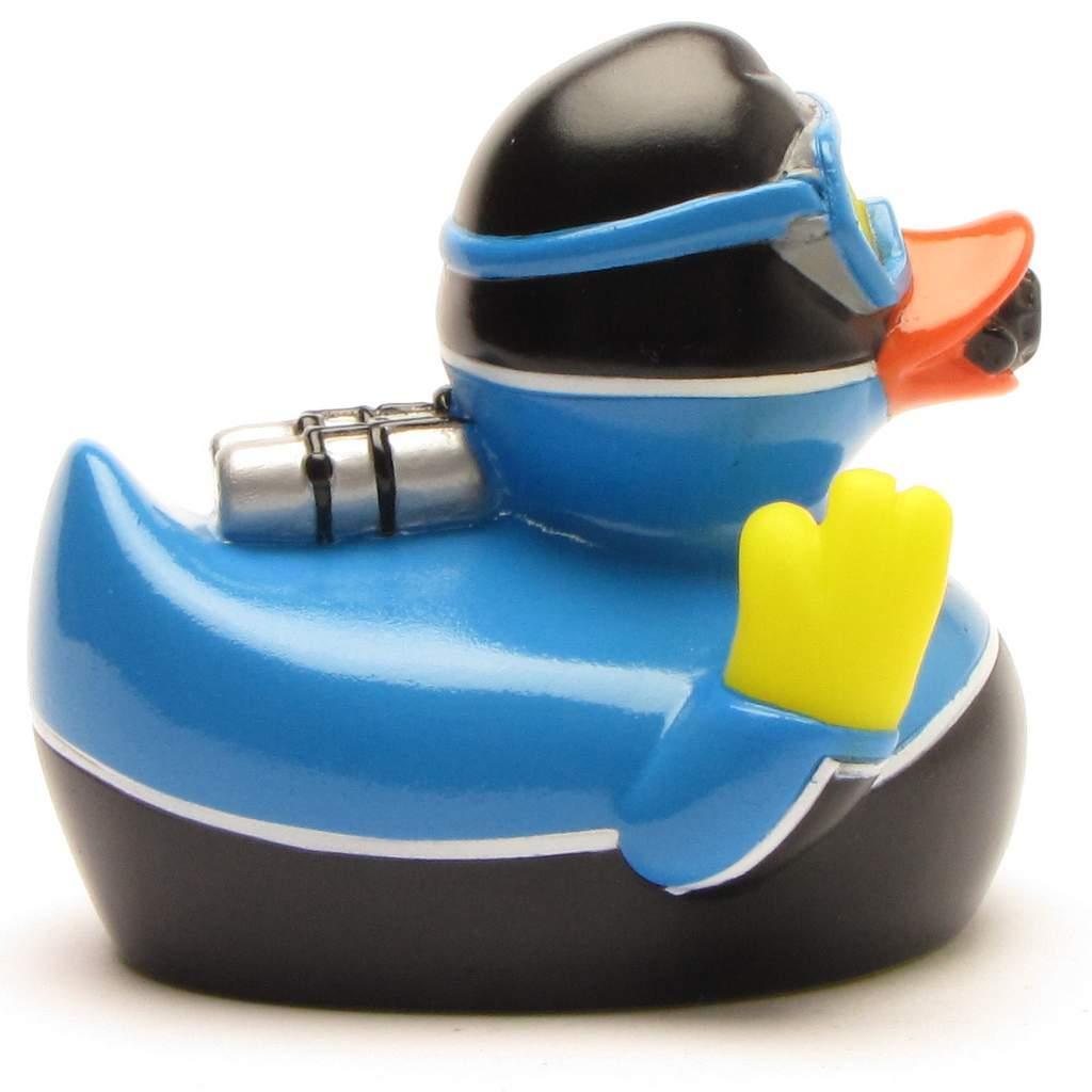 Un canard en caoutchouc déguisé en plongeur, portant un casque et des lunettes de plongée noirs, une combinaison bleue, des palmes jaunes et une bouteille d'air argentée sur le dos.