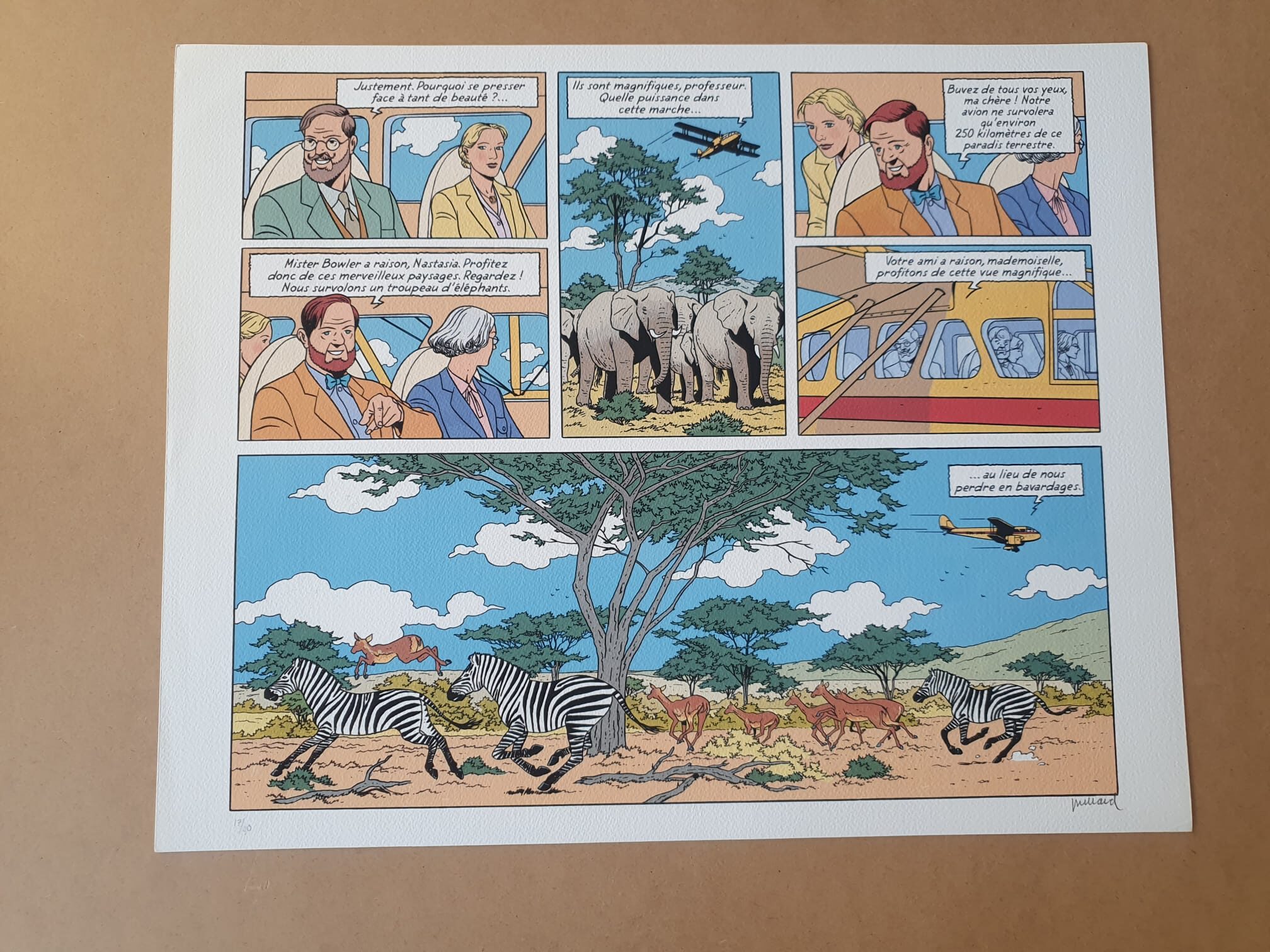 Une lithographie de bande dessinée intitulée « Lithographie André Juillard – Blake et Mortimer : Planche – 40 × 50 cm » représente des personnes à bord d'un véhicule de safari observant des éléphants et des zèbres dans la savane africaine, avec des dialogues en français dans des bulles au-dessus des personnages.