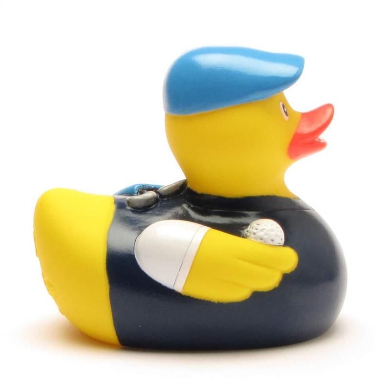 Un canard en caoutchouc déguisé en golfeur, coiffé d'une casquette bleue et vêtu d'une tenue bleu marine, tenant une balle de golf dans une aile.