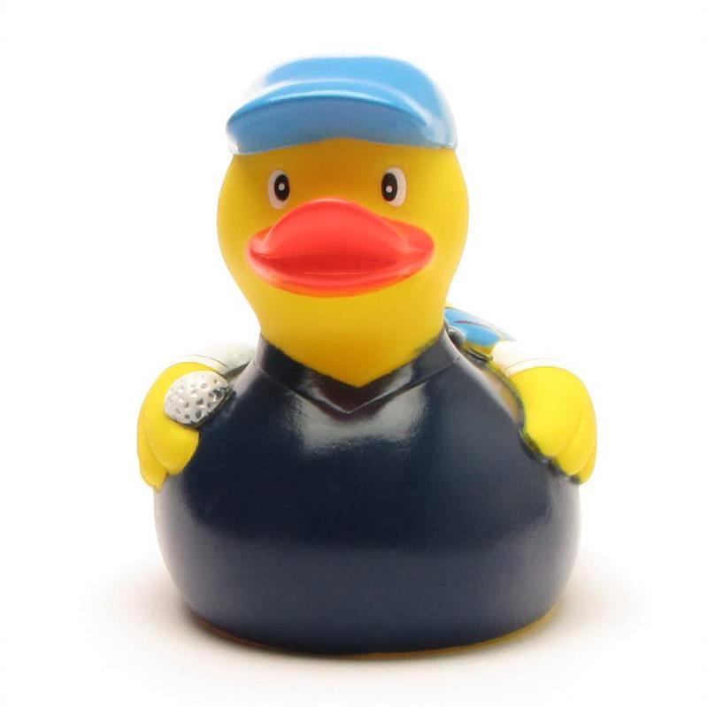 Un canard en caoutchouc jaune déguisé en golfeur, coiffé d'une casquette bleue et vêtu d'un polo bleu marine, tenant une balle de golf dans une aile.
