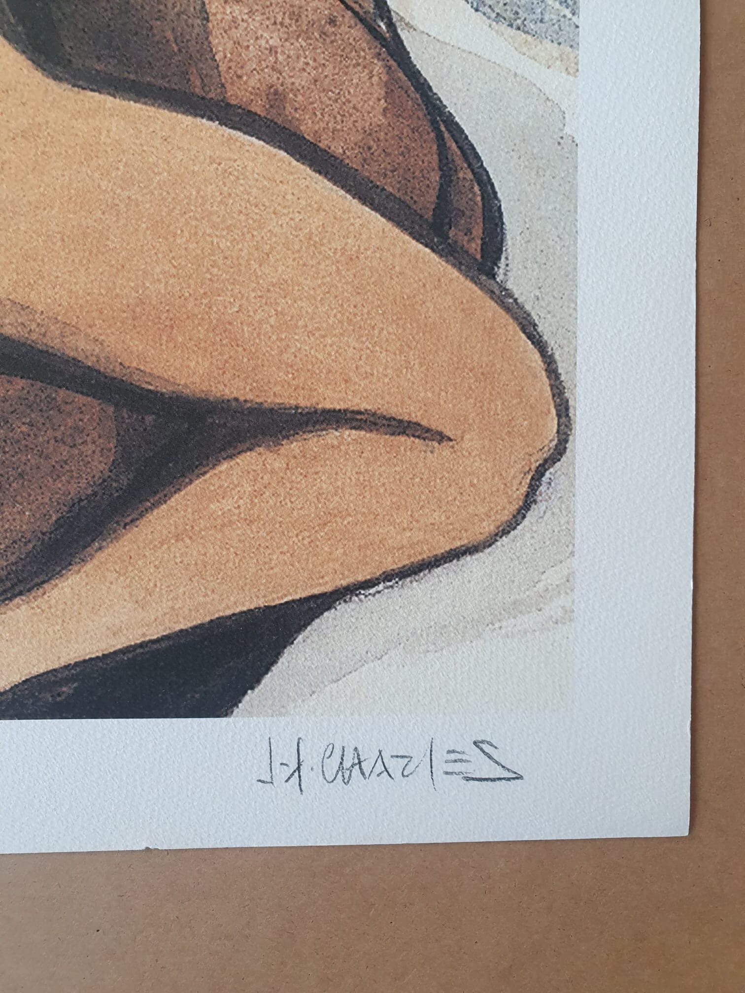 Un gros plan de la reproduction « Lithographie Jean-François Charles – Enlacé dans un lit – 40 × 50 cm » montre une partie du bras et de la jambe pliés d’une personne sur du papier texturé, la signature de l’artiste étant visible dans la marge blanche sous l’image.