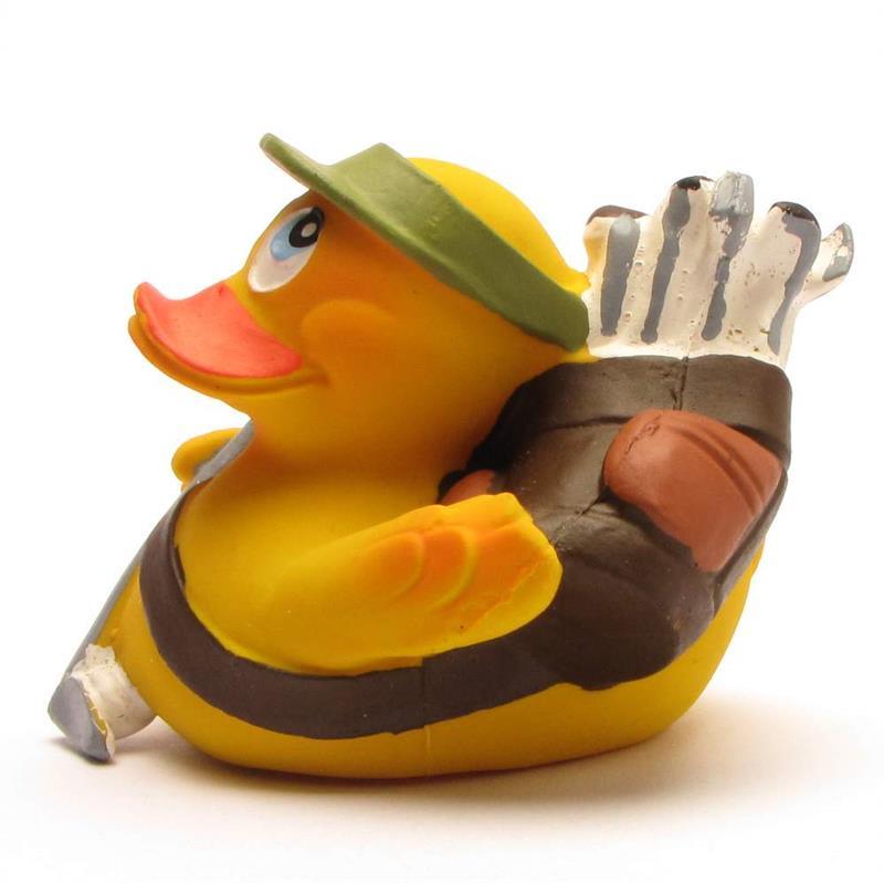 Un canard en caoutchouc jaune déguisé en golfeur, coiffé d'une visière verte et portant sur le dos un sac de golf marron contenant des clubs de golf argentés.