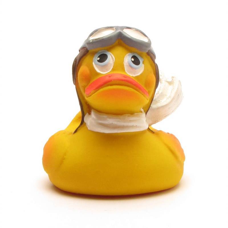 Un canard en caoutchouc jaune porte des lunettes d'aviateur et une écharpe blanche, ce qui lui donne l'air d'un pilote. Il a un bec orange et l'air triste.