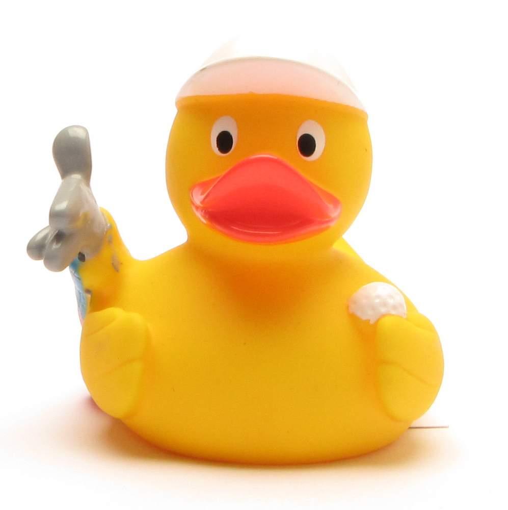 Un canard en caoutchouc jaune coiffé d'une casquette blanche tient un petit lapin gris dans une aile et une balle blanche dans l'autre, sur un fond blanc.