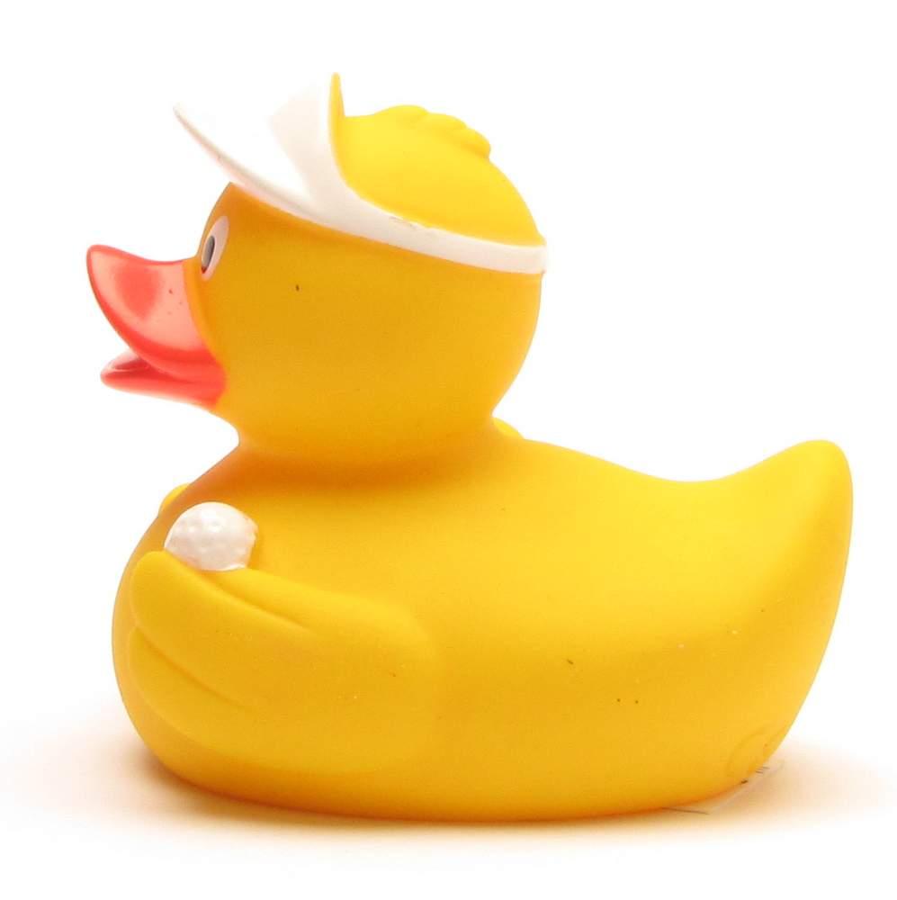 Canard en caoutchouc jaune portant une visière blanche, tenant une petite balle de golf blanche sous son aile. Le canard est tourné vers la gauche, sur un fond blanc uni.