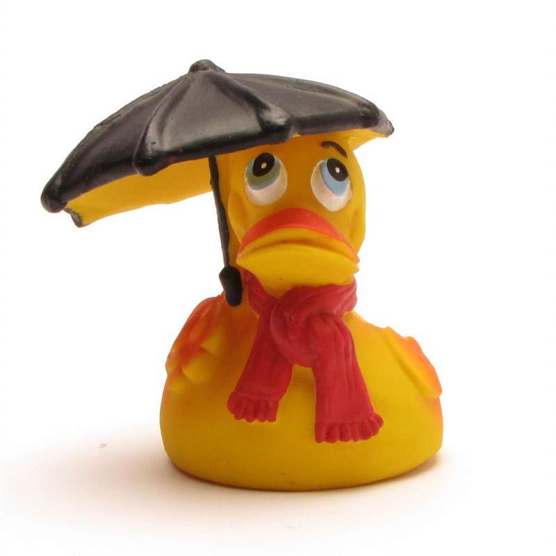 Un canard en caoutchouc jaune portant une écharpe rouge et tenant un parapluie noir au-dessus de sa tête, le regard tourné vers le ciel, l'air inquiet.