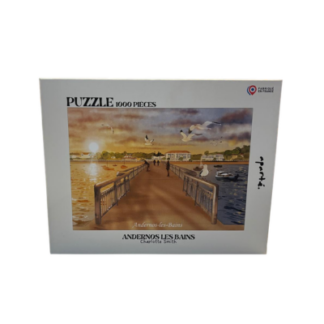 Une boîte de puzzle de 1 000 pièces intitulée « Puzzle Andernos-les-Bains – 1 000 pièces » représente une promenade au-dessus de l'eau au coucher du soleil, avec des oiseaux en vol et des bâtiments en arrière-plan. Sur la boîte figurent les inscriptions « Andernos-Les-Bains » et « Charlotte Smith ».