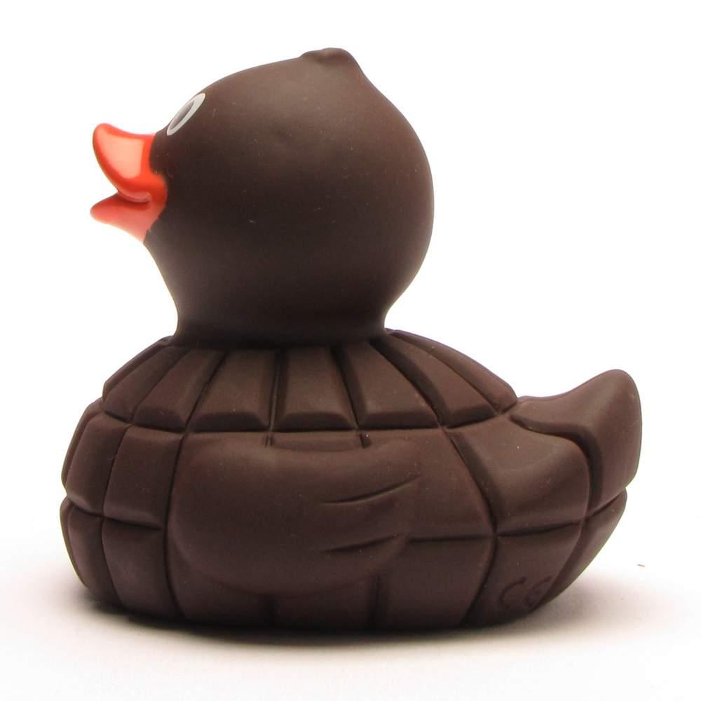Un canard en caoutchouc conçu pour donner l'impression d'être en chocolat, avec un corps marron, une forme arrondie et un bec orange, représenté de profil sur un fond blanc.