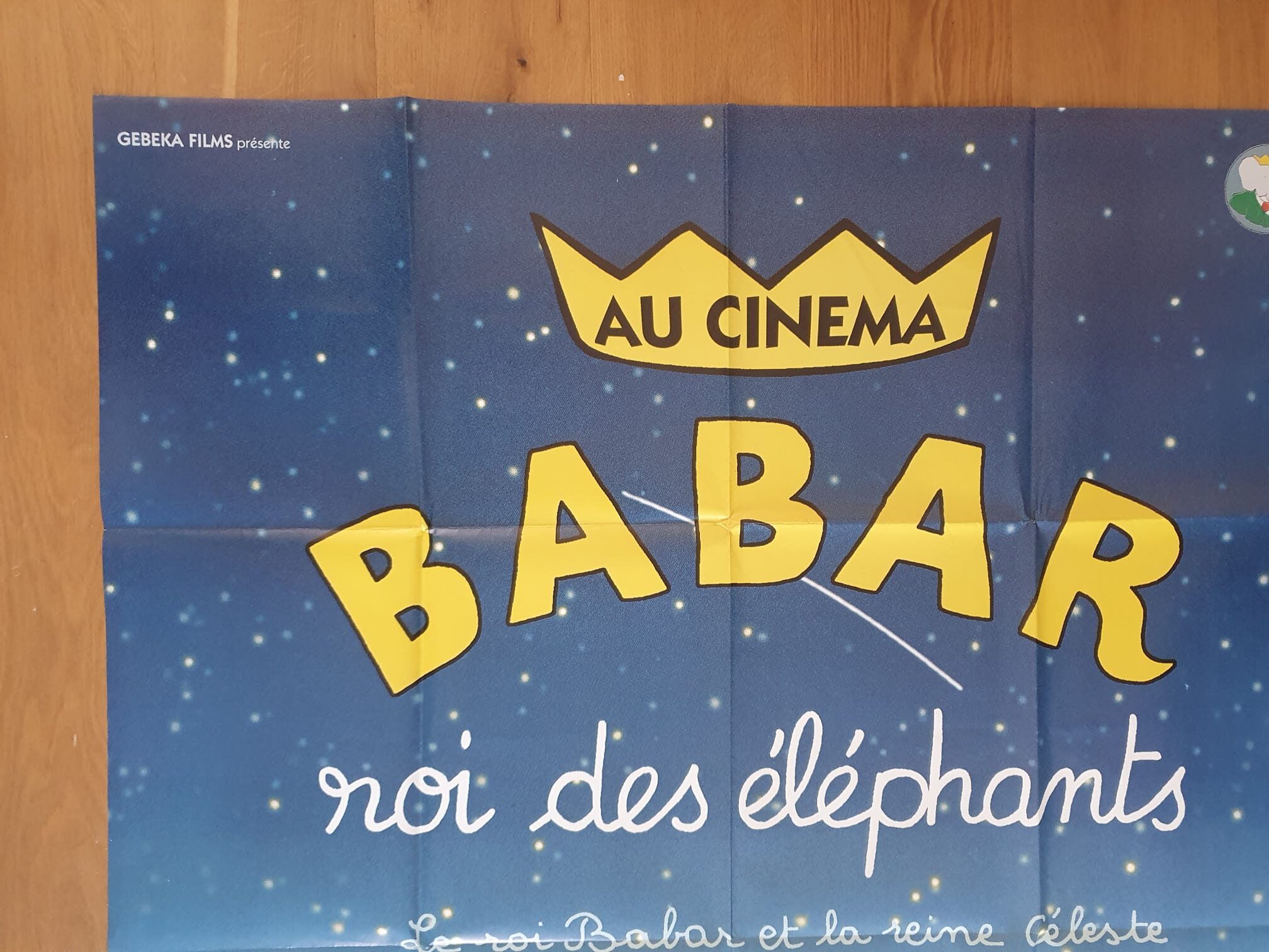 Affiche de cinéma « Babar, roi des éléphants » – 120 × 162 cm : une affiche illustrée d’un fond bleu étoilé, d’une couronne jaune et du texte « Au Cinéma Babar roi des éléphants » en français, destinée à la promotion du film sur Babar l’éléphant.